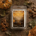 Pumpkin and Patchouli wax melt clamshell surrounded by a whole pumpkin, pecan pralines, autumn leaves, and pumpkin seeds on a dark wood surface